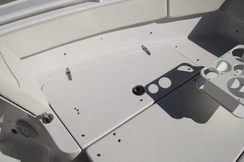 Slide: The Image of 2023 Sea Hunt Ultra 255 SE boat interior with cup holders and storage compartment. - 9