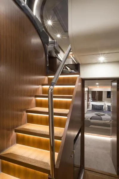 Slide: The Image of Interior of 2024 Belize 66 Sedan yacht with illuminated wooden staircase. - 11