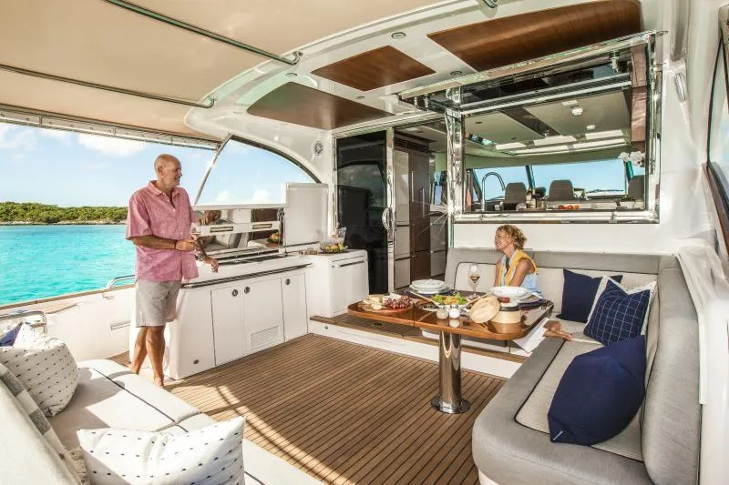 Slide: The Image of 2024 Belize 66 Sedan yacht interior with people dining and relaxing. - 6