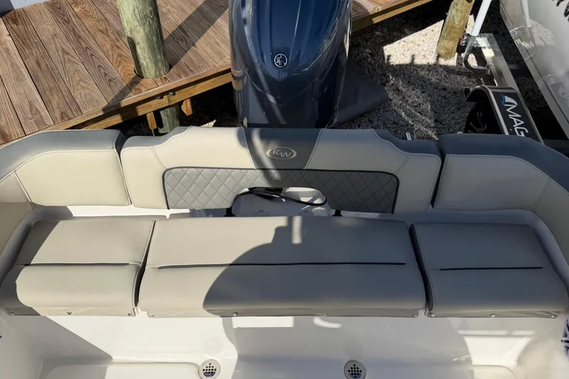 Slide: The Image of 2026 Key West 203 FS boat interior with cushioned seating and motor, docked outdoors. - 13