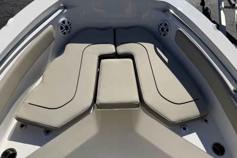 Slide: The Image of 2026 Key West 203 FS boat interior with beige cushioned seating and stainless steel accents. - 16