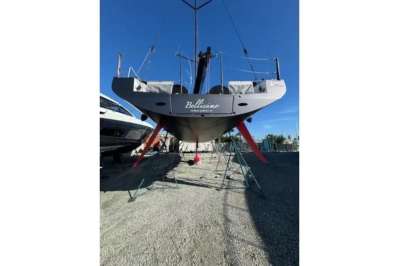Slide: The Image of Sailboat Neo 43 Romo 2024 on stands, viewed from stern, clear sky background. - 6
