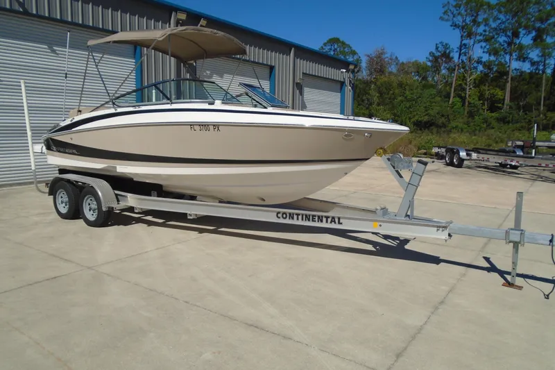 Slide: The Image of 2014 Regal 2300 Bowrider on trailer, parked outdoors near storage facility. - 1