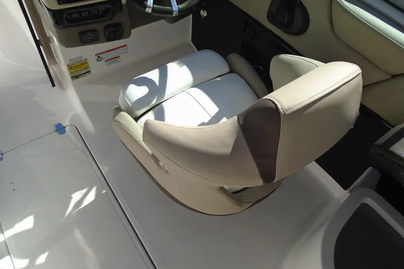 Slide: The Image of 2014 Regal 2300 Bowrider interior with beige captain's chair and steering wheel. - 14