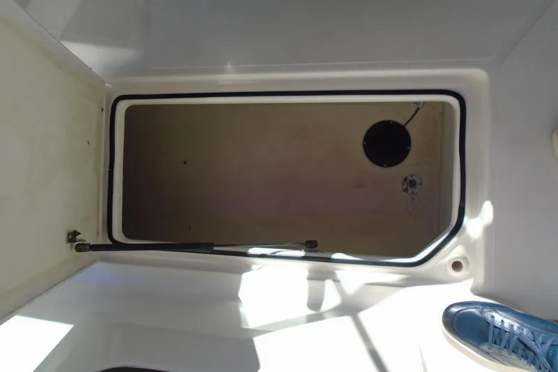 Slide: The Image of Open storage compartment on 2014 Regal 2300 Bowrider boat, with visible shoe. - 17