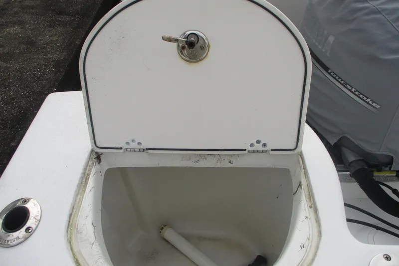Slide: The Image of Open storage compartment on 2005 Sailfish 236 CC boat with visible engine cover. - 14