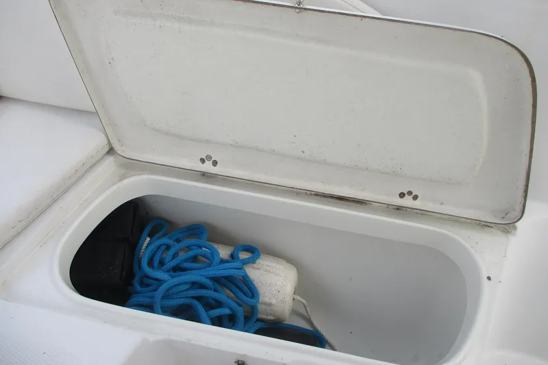 Slide: The Image of Open storage compartment on 2005 Sailfish 236 CC boat with blue rope and fender. - 17