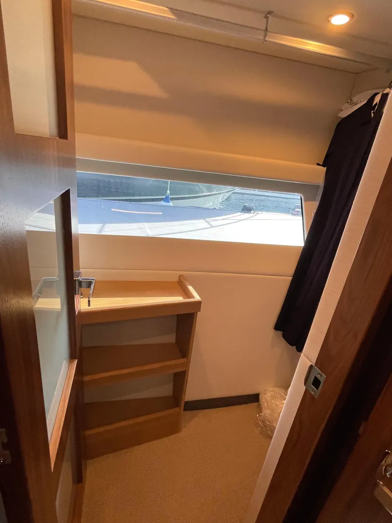 Slide: The Image of Interior of 2022 Riviera 505 SUV yacht with window view and wooden shelves. - 33