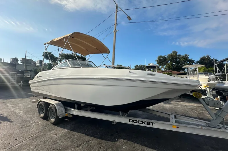 The Image of 2020 Hurricane SunDeck 217 OB boat on trailer with canopy, parked outdoors. - 0