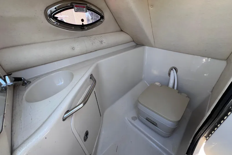 Slide: The Image of 2006 Sea Ray 240 Sundeck interior with sink and portable toilet. - 27