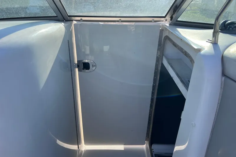 Slide: The Image of 2006 Sea Ray 240 Sundeck interior cabin with closed door and window view. - 31