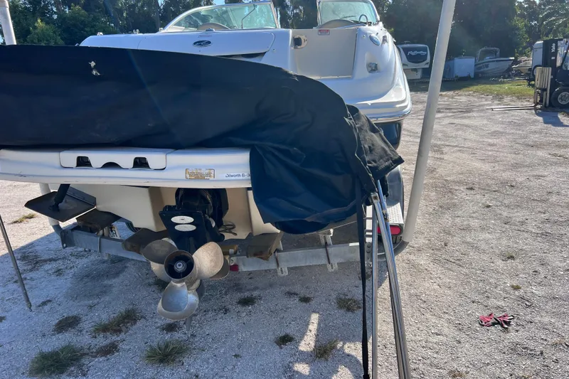 Slide: The Image of 2006 Sea Ray 240 Sundeck boat on trailer, covered, with visible propeller. - 33