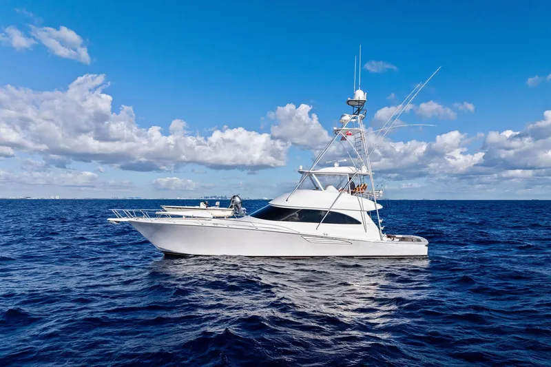 The Image of 2015 Viking 66' Convertible yacht cruising on open ocean under blue sky. - 0