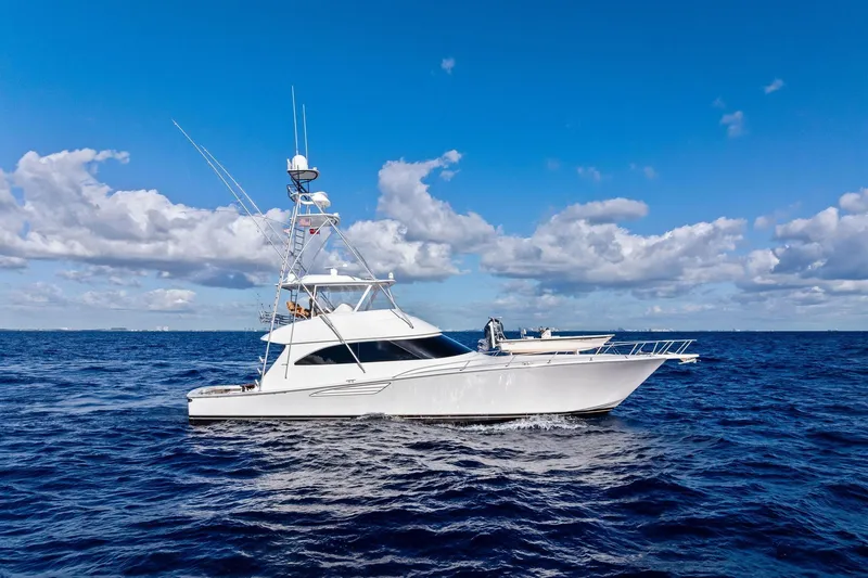 Slide: The Image of 2015 Viking 66' Convertible yacht cruising on open ocean under blue sky. - 1