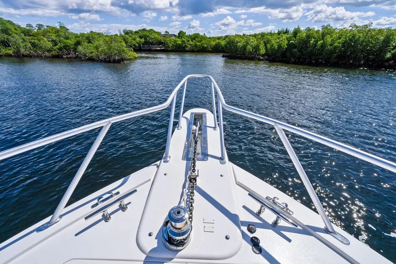 Slide: The Image of Bow view of 2015 Viking 66' Convertible yacht navigating serene waters. - 13