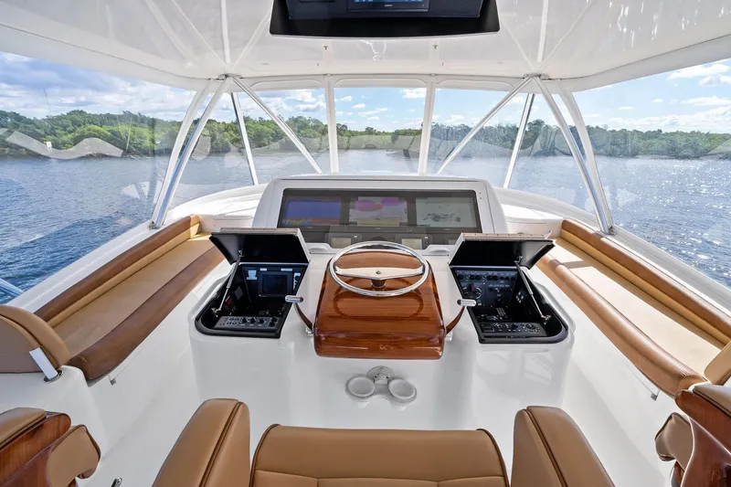 Slide: The Image of Helm of 2015 Viking 66' Convertible yacht with luxurious seating and advanced controls. - 16