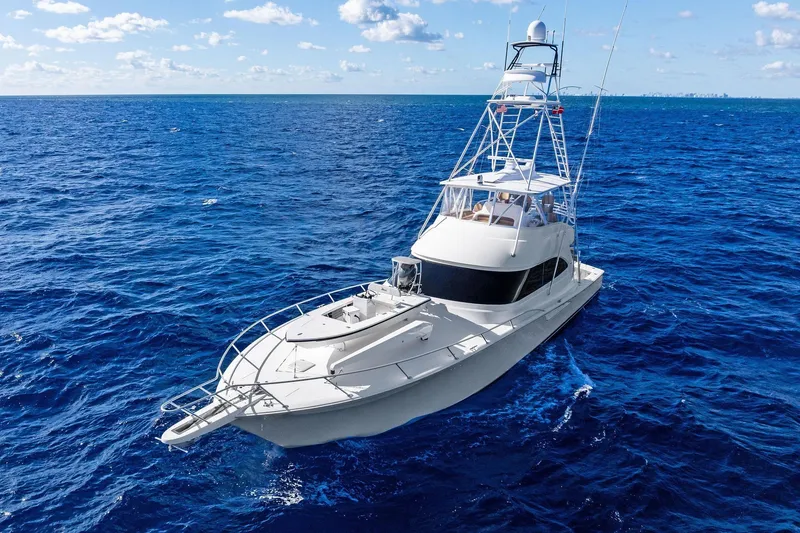 Slide: The Image of 2015 Viking 66' Convertible yacht cruising on open blue ocean under clear sky. - 2