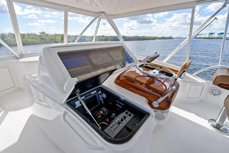 Slide: The Image of Helm of 2015 Viking 66' Convertible yacht with advanced navigation controls and scenic water view. - 20