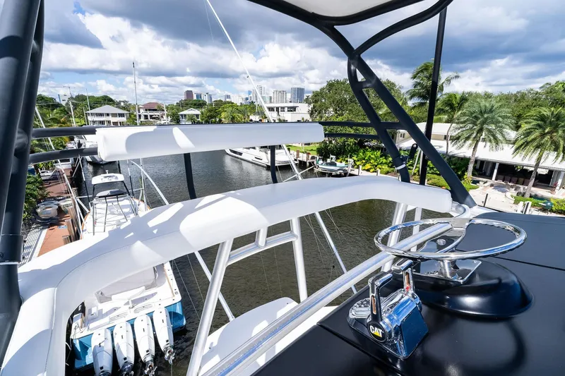 Slide: The Image of 2015 Viking 66' Convertible yacht helm with marina view, featuring modern controls and seating. - 25