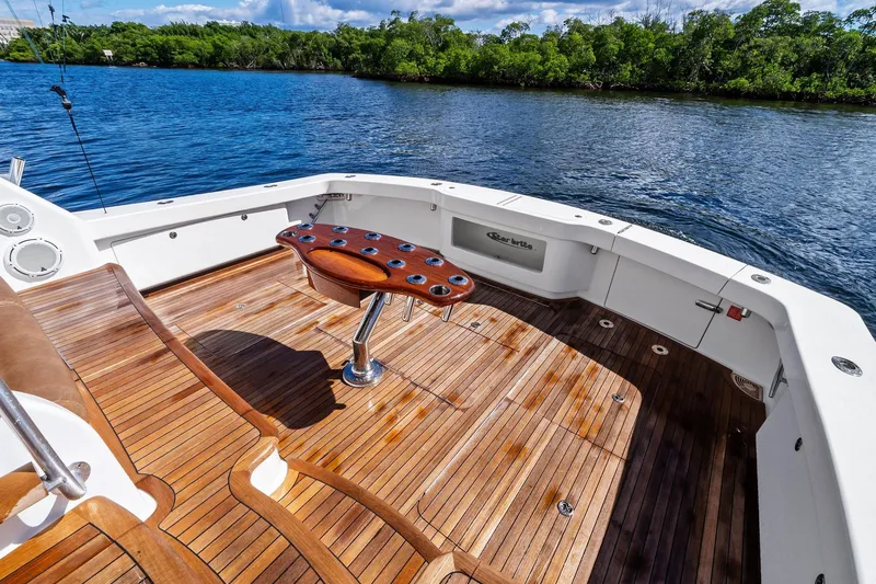 Slide: The Image of 2015 Viking 66' Convertible yacht with teak deck, fishing rod holders, and scenic water view. - 27