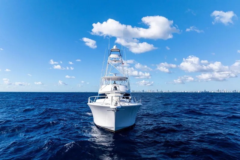 Slide: The Image of 2015 Viking 66' Convertible yacht cruising on open ocean under blue sky. - 3