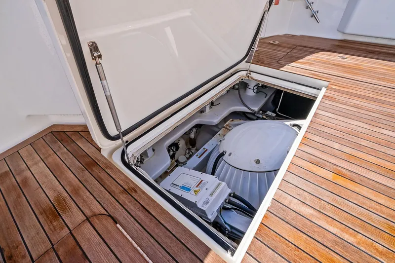 Slide: The Image of Open hatch on 2015 Viking 66' Convertible yacht, revealing mechanical components on teak deck. - 31