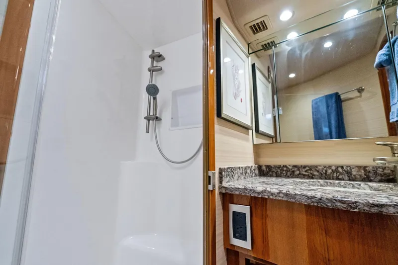 Slide: The Image of Luxurious bathroom in 2015 Viking 66' Convertible yacht with marble countertop and modern shower. - 42