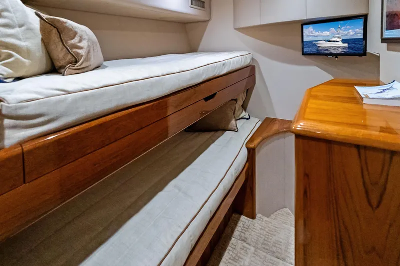 Slide: The Image of Interior of 2015 Viking 66' Convertible yacht with bunk beds and wooden desk. - 47