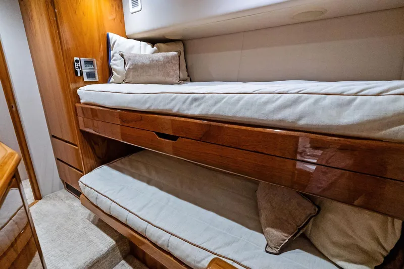 Slide: The Image of Bunk beds in 2015 Viking 66' Convertible yacht cabin with wooden finish and cozy bedding. - 48
