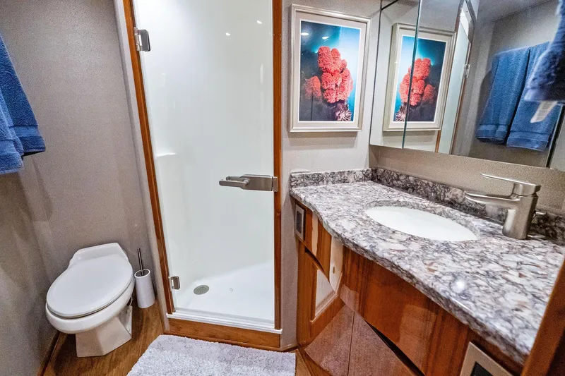 Slide: The Image of Luxurious bathroom in 2015 Viking 66' Convertible yacht with marble countertop and shower. - 49