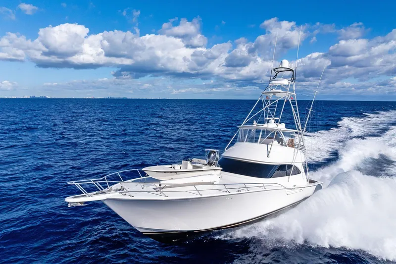 Slide: The Image of 2015 Viking 66' Convertible yacht cruising on open ocean under blue sky. - 5