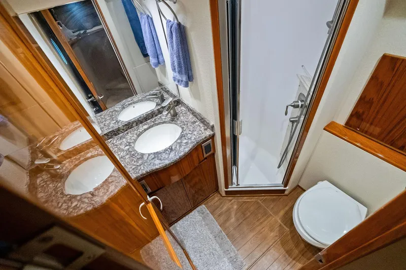 Slide: The Image of Luxurious bathroom in 2015 Viking 66' Convertible yacht with dual sinks and shower. - 51