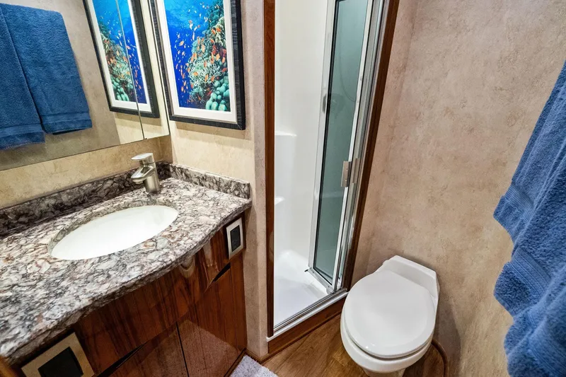 Slide: The Image of Luxurious bathroom in 2015 Viking 66' Convertible yacht with marble countertop and shower. - 52