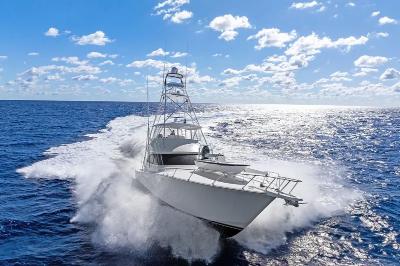 Slide: The Image of 2015 Viking 66' Convertible yacht cruising on open ocean under clear blue sky. - 6