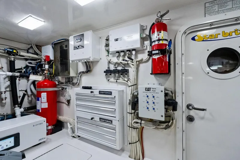 Slide: The Image of Engine room of 2015 Viking 66' Convertible yacht with fire safety equipment and control panels. - 60