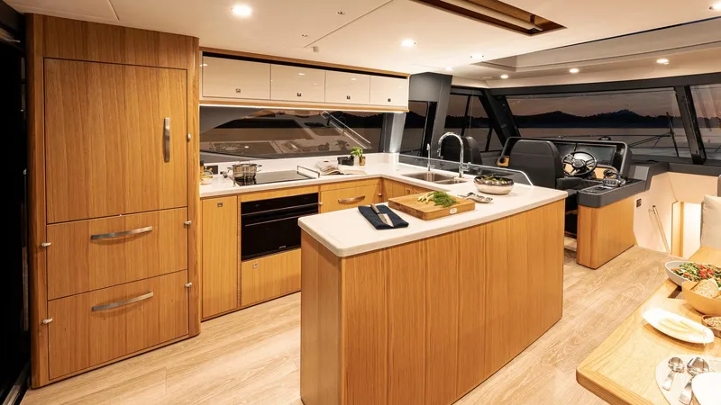Slide: The Image of Luxurious kitchen interior of 2024 Riviera 585 SUV yacht with modern appliances and wooden cabinetry. - 14