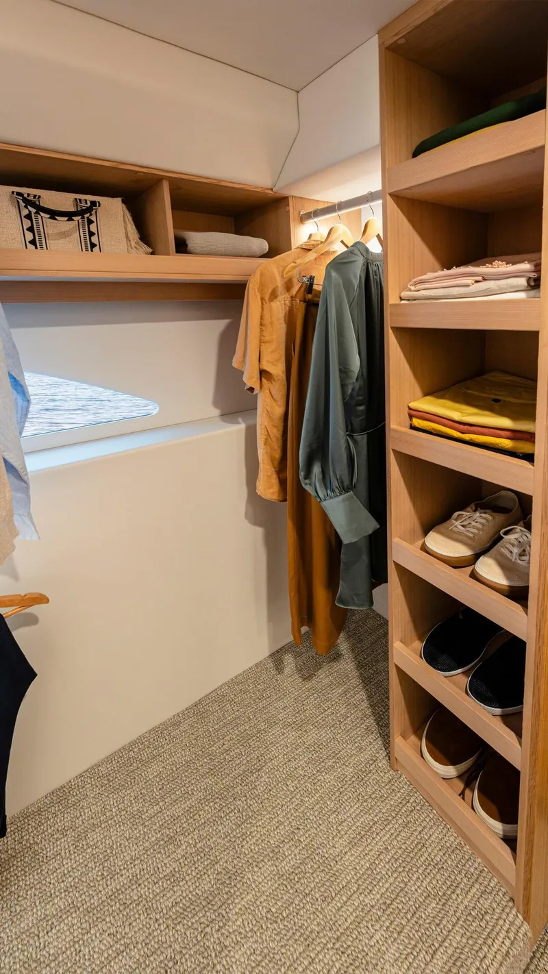 Slide: The Image of 2024 Riviera 585 SUV yacht interior closet with shelves and hanging clothes - 24