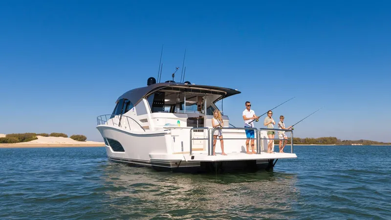 Slide: The Image of 2024 Riviera 585 SUV yacht with people fishing on deck in open water. - 5