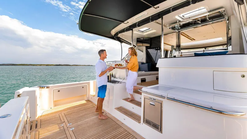 Slide: The Image of Couple enjoying the deck of a 2024 Riviera 585 SUV yacht. - 7