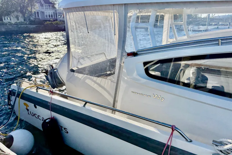 Slide: The Image of 2023 Nimbus Weekender 9 boat docked by waterfront homes. - 3