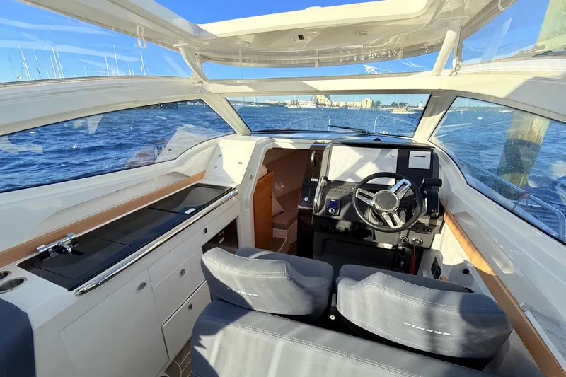 Slide: The Image of 2023 Nimbus Weekender 9 boat interior with steering wheel, dashboard, and seating. - 4