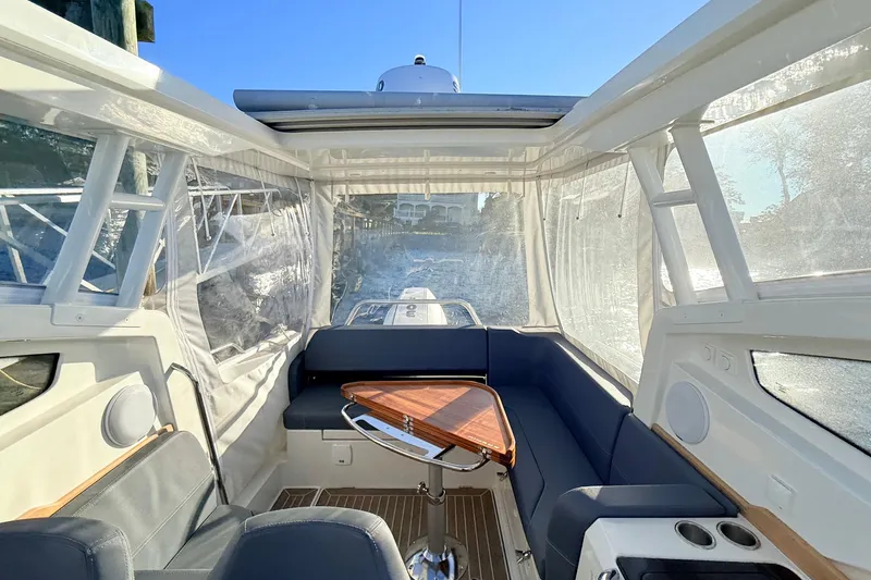 Slide: The Image of 2023 Nimbus Weekender 9 interior with seating, wooden table, and clear windows on a sunny day. - 6