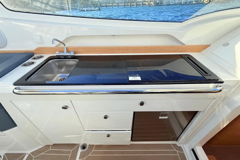 Slide: The Image of 2023 Nimbus Weekender 9 boat kitchen with sink and stove, featuring sleek design. - 9