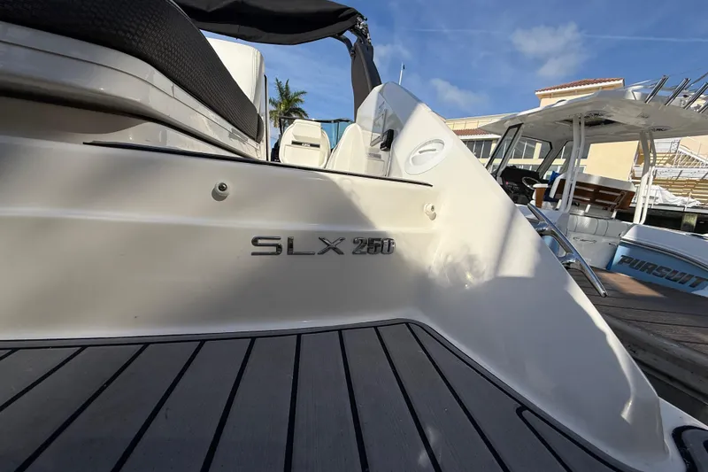 Slide: The Image of 2018 Sea Ray SLX 250 boat docked, showcasing sleek design and branding. - 15