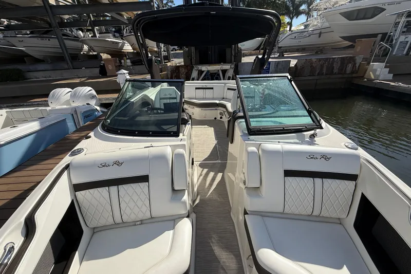 Slide: The Image of 2018 Sea Ray SLX 250 boat with luxurious seating and sleek design at a marina. - 20