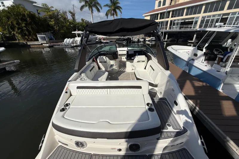 Slide: The Image of 2018 Sea Ray SLX 250 boat docked, featuring spacious seating and sleek design. - 21