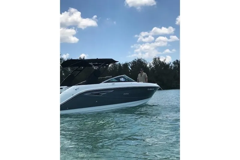 Slide: The Image of 2018 Sea Ray SLX 250 boat docked, featuring spacious seating and sleek design. - 3