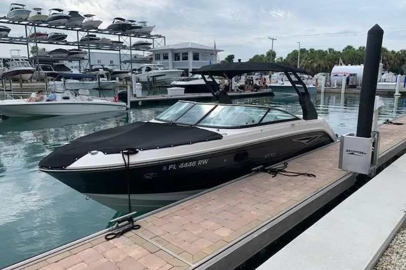 Slide: The Image of 2018 Sea Ray SLX 250 boat docked under a covered marina. - 4