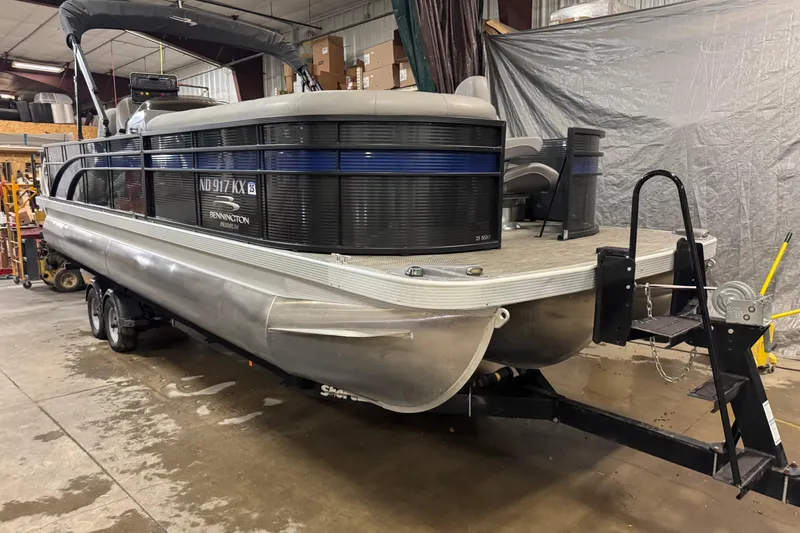 Slide: The Image of 2020 Bennington SXP 25 SSBXP pontoon boat in indoor storage on trailer. - 2