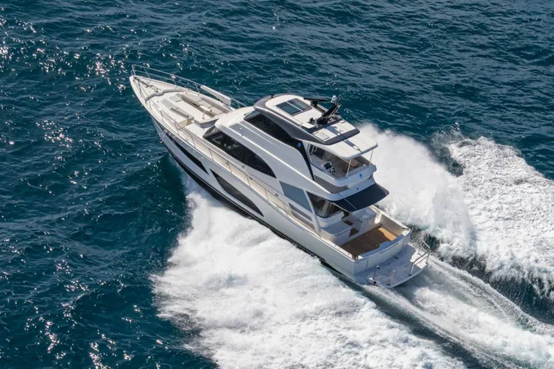 Slide: The Image of 2026 Riviera 64 Sports Motor Yacht Series II cruising on open water. - 1